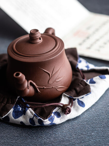 Handmade in China, our Shuye Teapot (featured on MastersTeas.com) is a Pan Hu shape and made from authentic zisha clay. The long spout and handle have been modeled to mimic bamboo, with leaves that adorn the belly. With a max capacity of 230 ml, it is ideal for gong fu style brewing all types of tea. Though it can be used for all types of tea. Yixing clay is extremely porous and absorbent. Hand wash with warm water only and let air dry. 